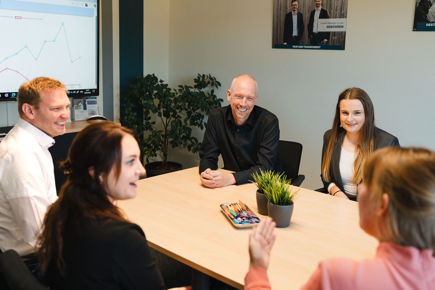 Mitarbeiter der Kanzlei Lotz und Partner sitzen zusammen am Besprechungstisch